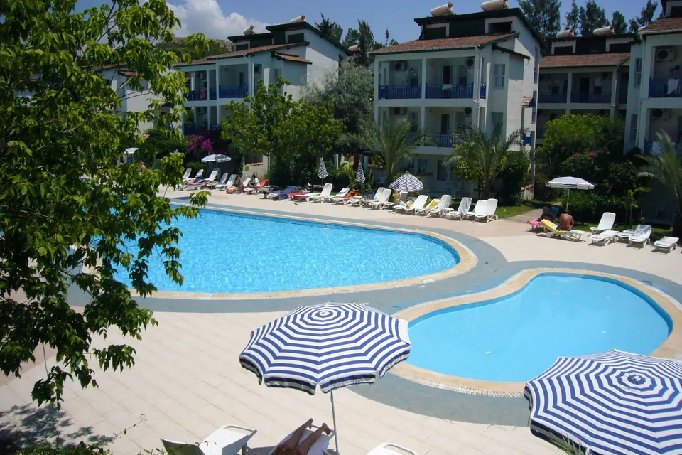 Tatil köyü havuzu ve şemsiyeler